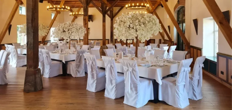 Hochzeitssaal mit dekorierten Tischen und Stuhlhussen
